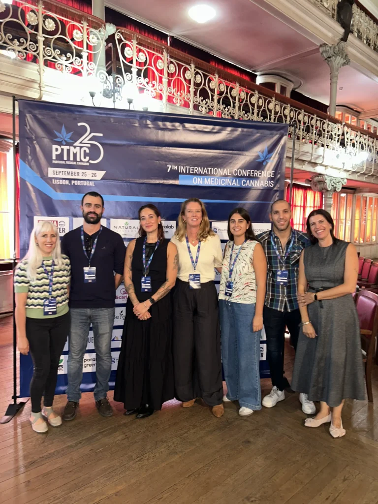 Seven people sanding in front of PTMC exhibition banner